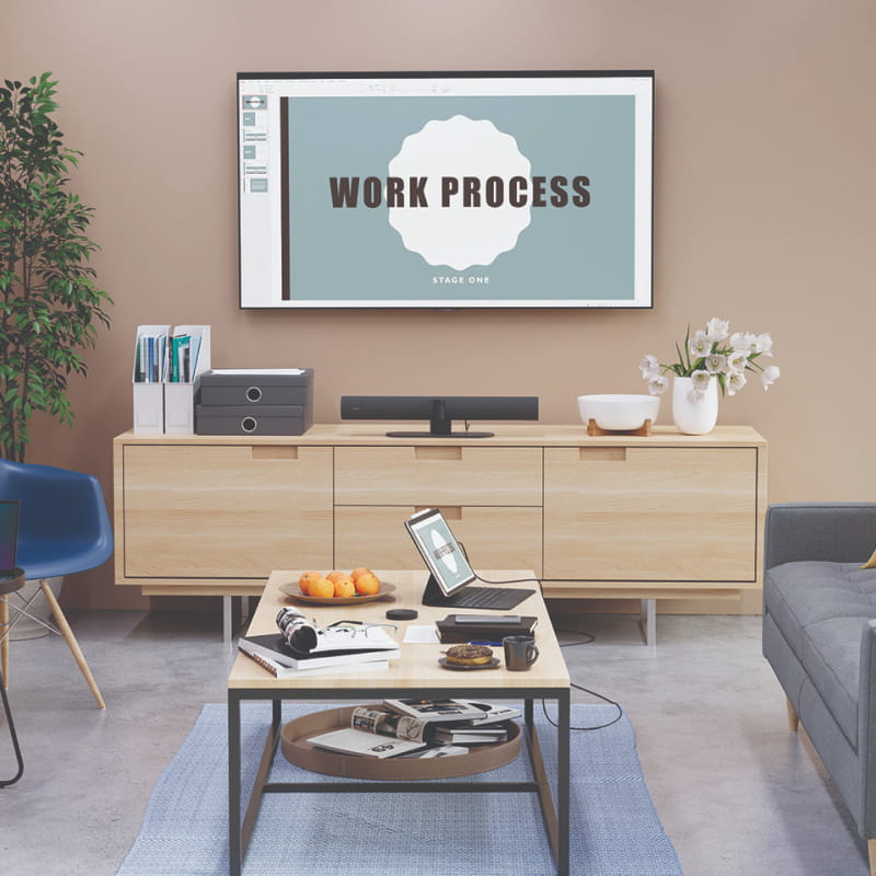 Jabra PanaCast 50 video conferencing solution with stand in a modern home office setup in front of a screen with a presentation