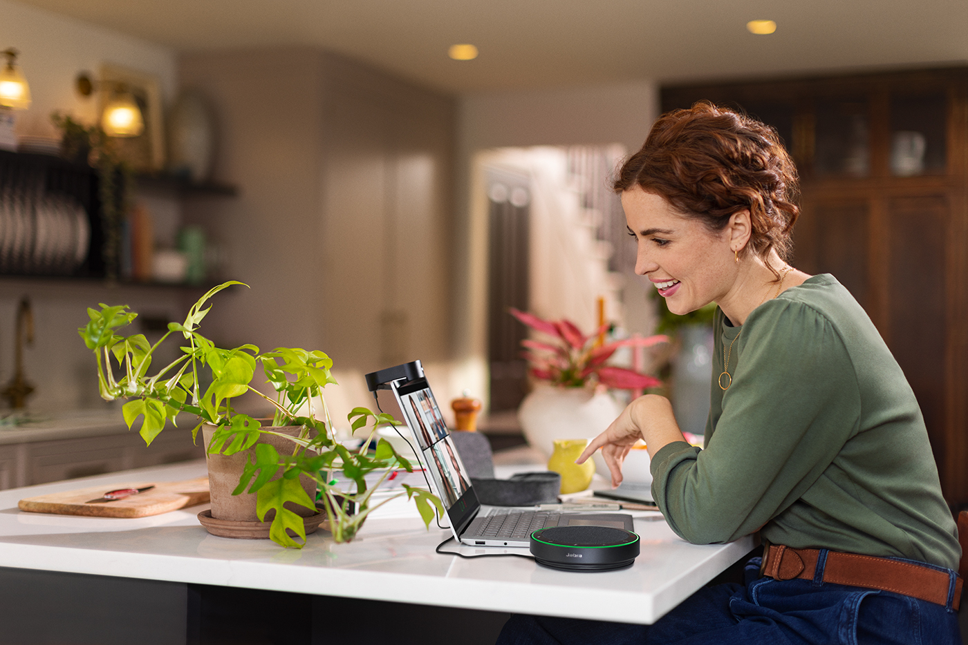 Woman working from home using a Jabra Speak2 75 speakerphone from her kitchen island