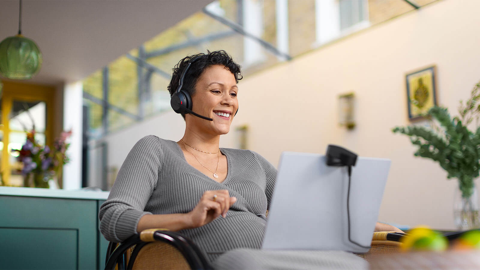 Frau trägt Jabra Evolve2 55 Headset und lächelt während eines Videoanrufs